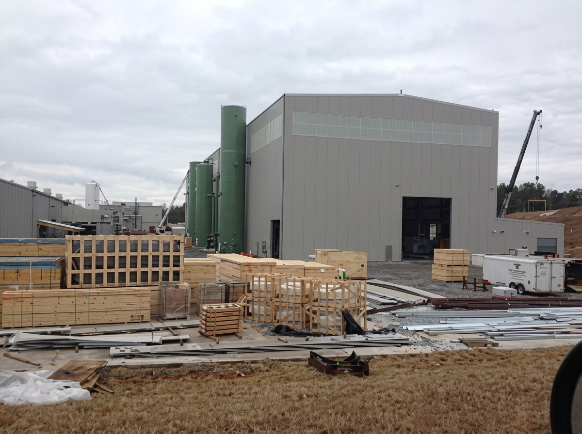 Industrial building with staged construction materials on site